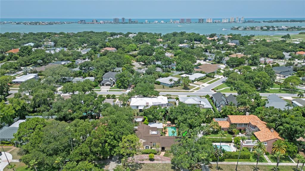 An aerial view shows a residential neighborhood with houses, swimming pools, and mature trees — 1330 INDIAN ROCKS ROAD, BELLEAIR, FL