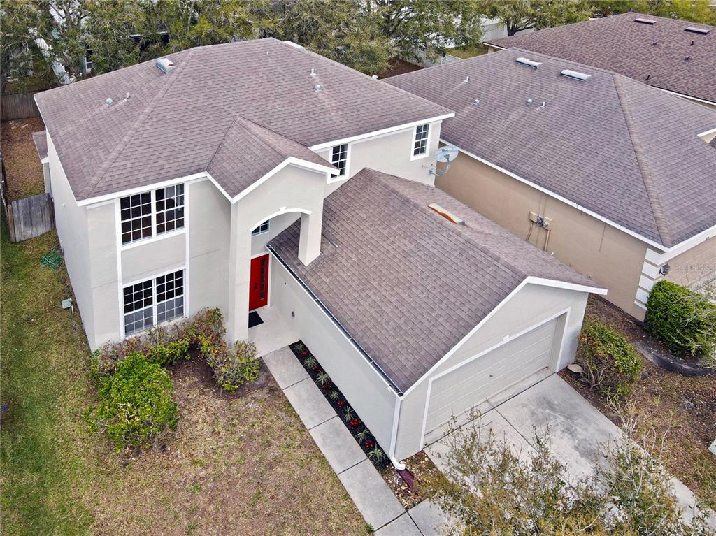 An aerial view shows a two-story house with a beige exterior, brown roof, and garage — 8212 CYPRESS BREEZE WAY, TAMPA, FL