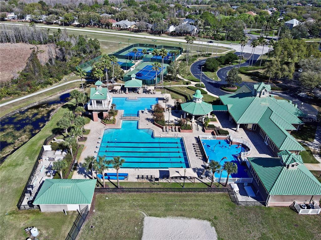 An aerial view shows a community pool complex with tennis courts and a clubhouse — 8212 CYPRESS BREEZE WAY, TAMPA, FL