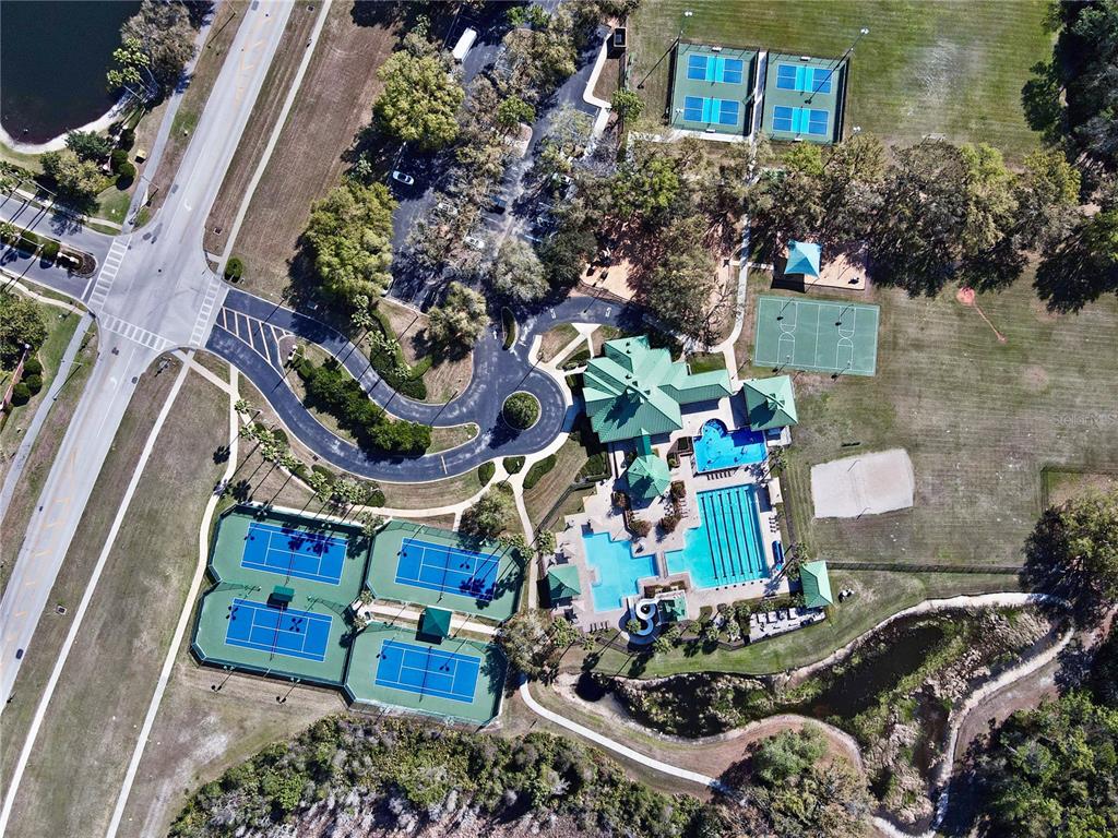 Aerial view of a community recreation center featuring tennis courts, swimming pools, and parking areas — 8212 CYPRESS BREEZE WAY, TAMPA, FL