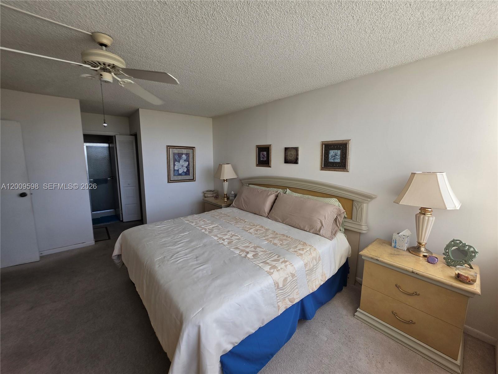 A bedroom features a bed with a beige comforter, a ceiling fan, and two nightstands — 3771 Environ Blvd # 649, Lauderhill FL 33319, LAUDERHILL, FL