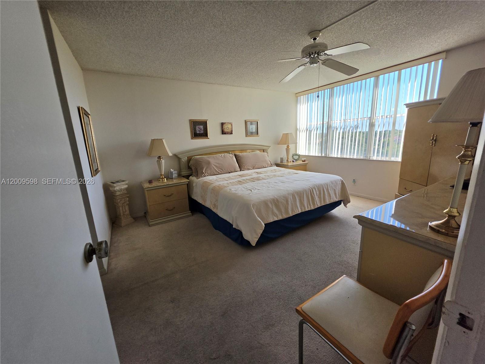 A bedroom features a bed, two nightstands, a dresser, and large windows with vertical blinds — 3771 Environ Blvd # 649, Lauderhill FL 33319, LAUDERHILL, FL