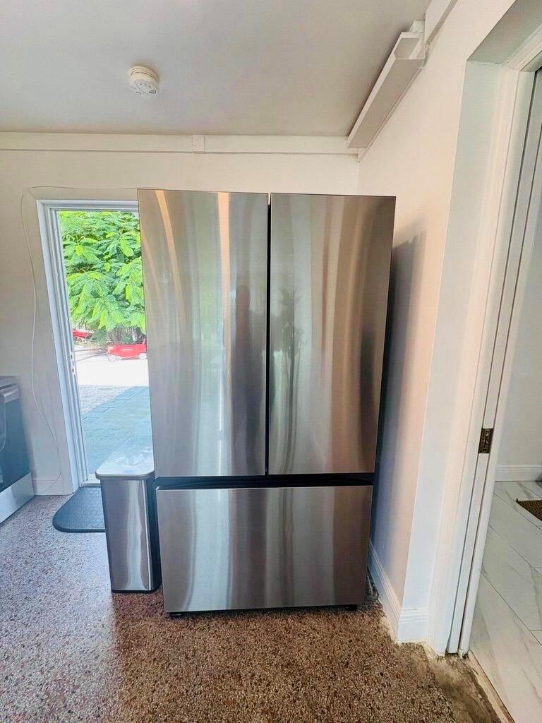 A stainless steel French door refrigerator stands in a kitchen next to a glass door — 2711 NE 11th Terrace, Pompano Beach FL 33064, POMPANO BEACH, FL