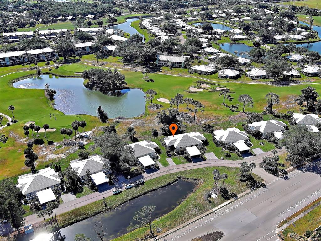 An aerial view of a residential community featuring houses, a golf course, and ponds — 262 CERROMAR WAY S UNIT 53, VENICE, FL