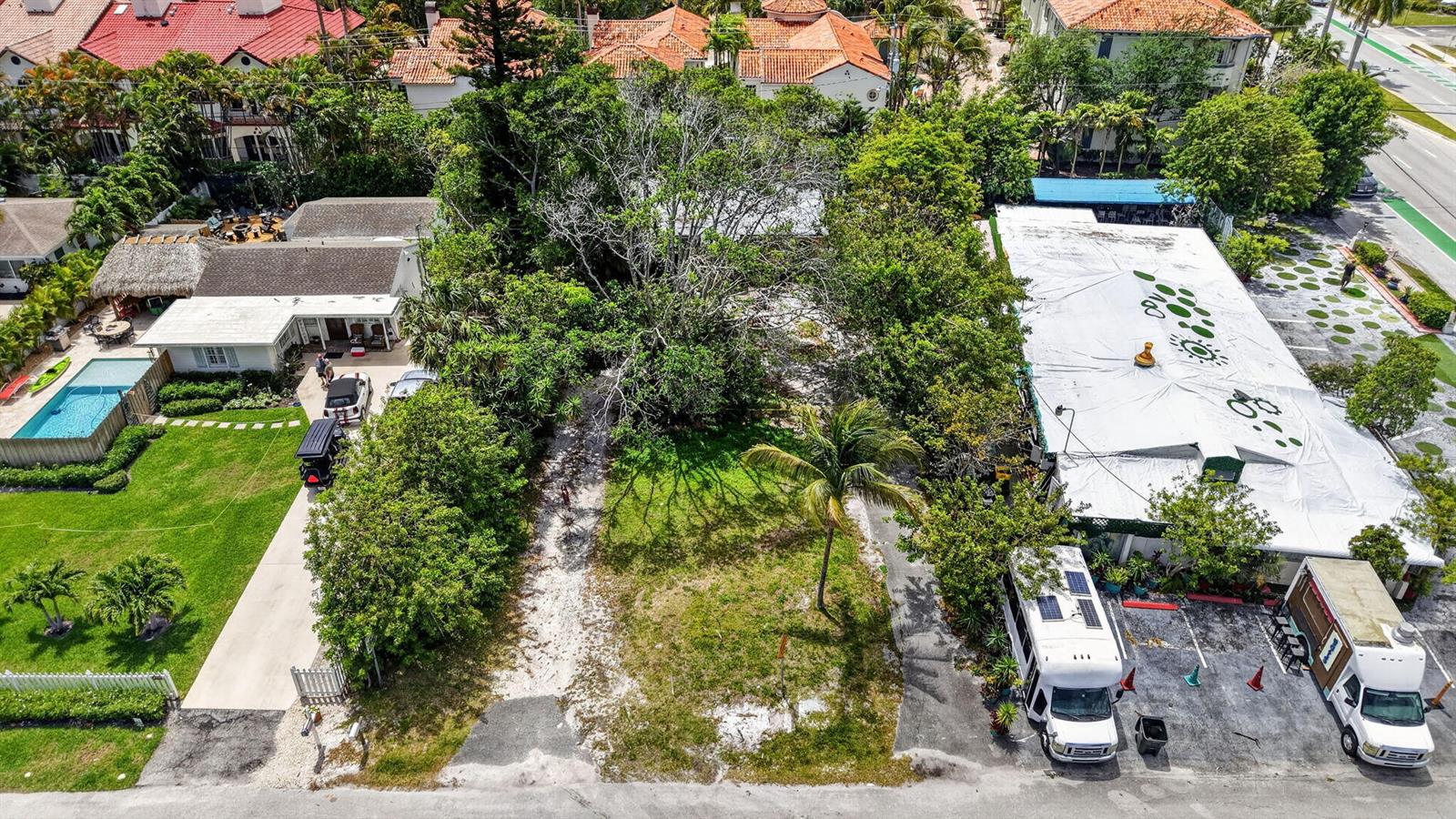 An aerial view shows a vacant lot situated between a residential house and a commercial building — 600 Allen Avenue, Delray Beach FL 33483, DELRAY BEACH, FL