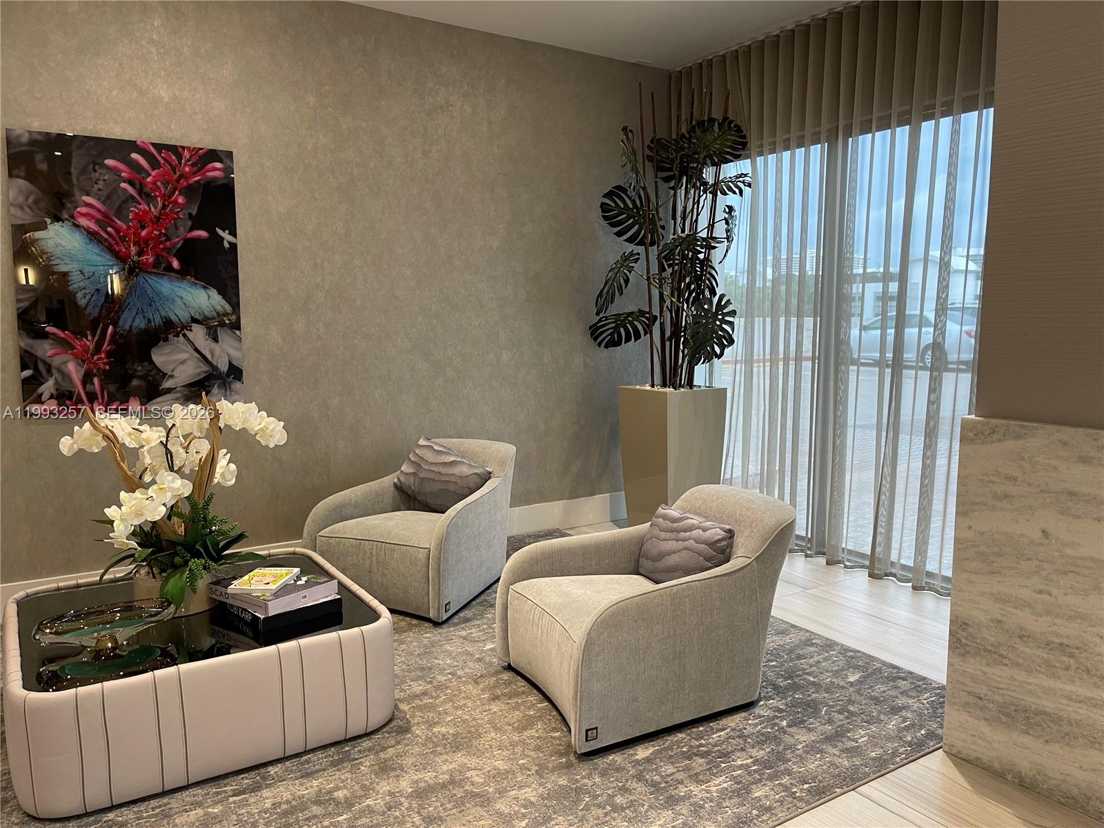 A modern seating area features two gray armchairs, a coffee table, and a large plant — 2301 S Ocean Dr # 607, Hollywood FL 33019, HOLLYWOOD, FL