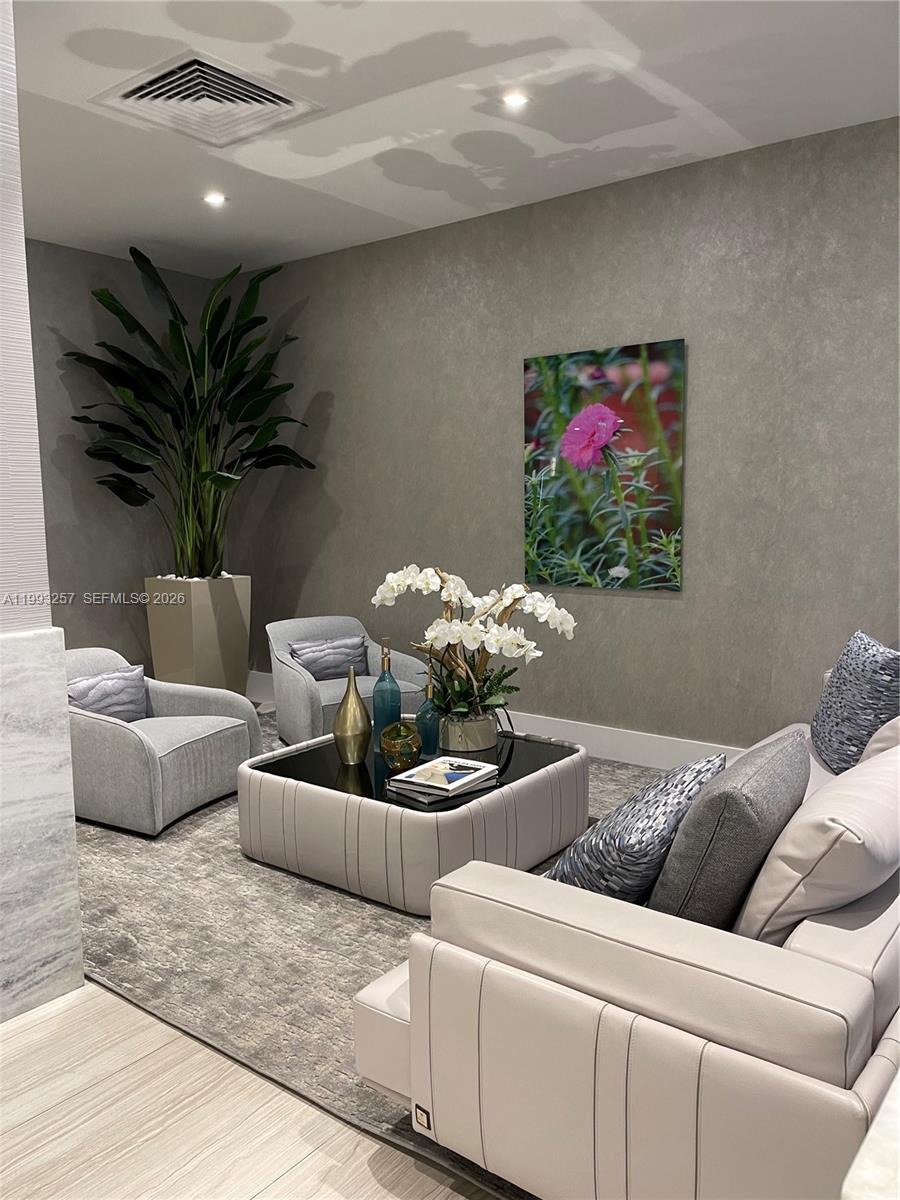 A modern living room features gray upholstered furniture, a square coffee table, and a large plant — 2301 S Ocean Dr # 607, Hollywood FL 33019, HOLLYWOOD, FL