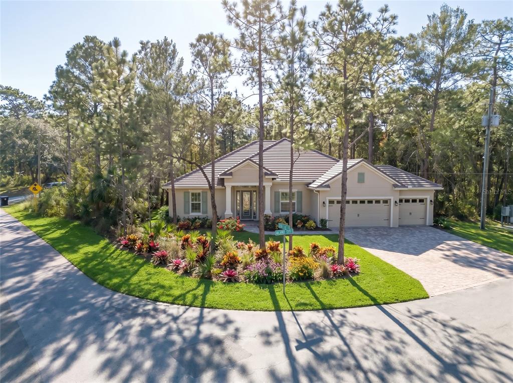 A single-story house with a tiled roof, three-car garage, and landscaped front yard — 30 BELLS OF IRELAND COURT, HOMOSASSA, FL