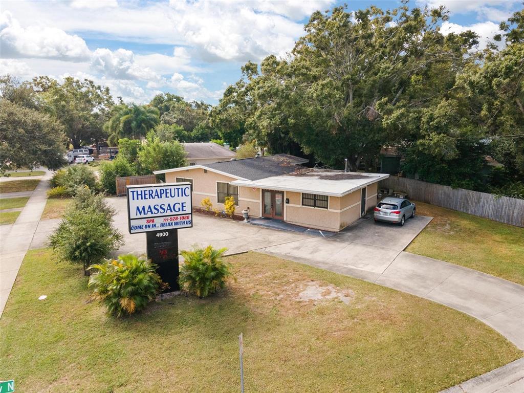 An aerial view shows a single-story commercial building with a massage spa sign out front — 4900 33RD AVENUE N, ST PETERSBURG, FL