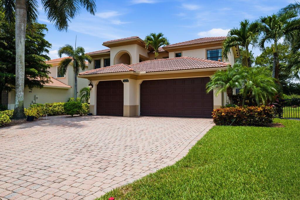 A two-story house with a tiled roof, a three-car garage, and a paved driveway — 8105 Ferentino Pass, Delray Beach FL 33446, DELRAY BEACH, FL