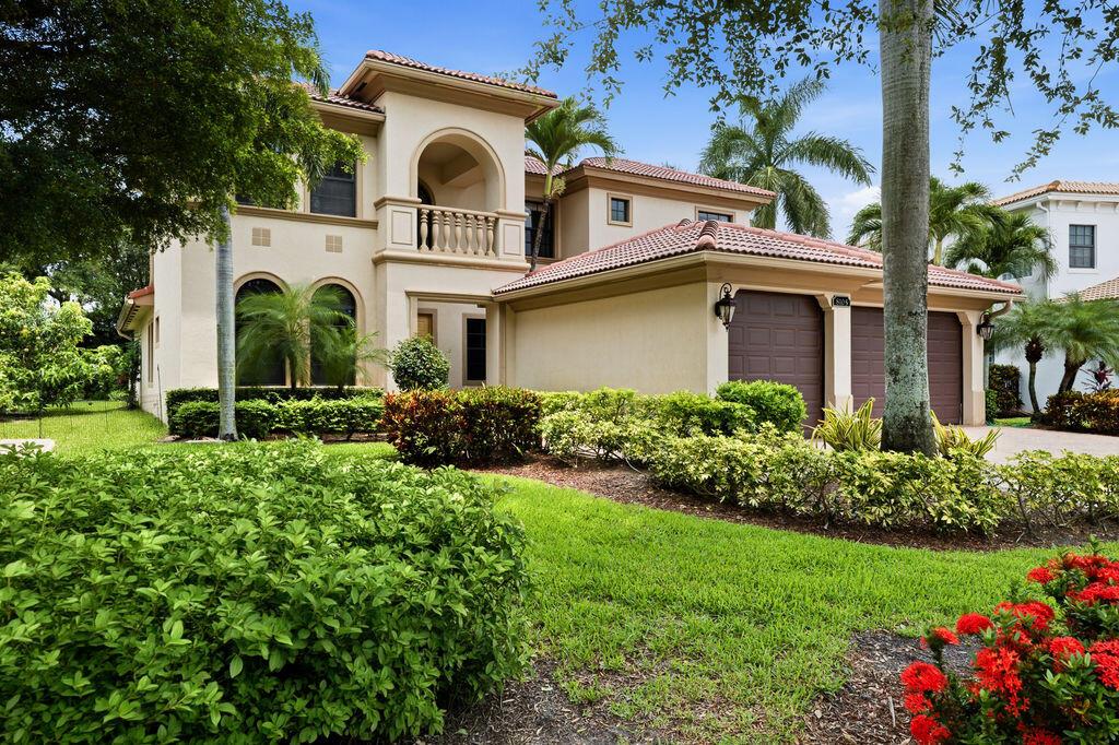 A two-story stucco house with a tile roof, arched balcony, and attached three-car garage — 8105 Ferentino Pass, Delray Beach FL 33446, DELRAY BEACH, FL