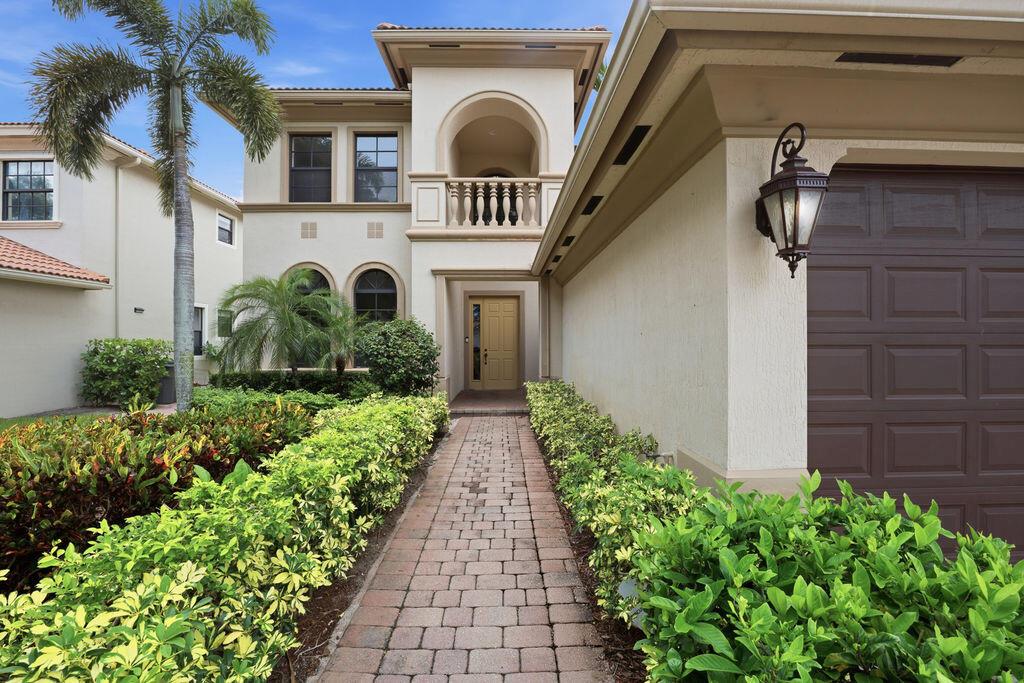 A brick walkway leads to the front entrance of a two-story stucco house — 8105 Ferentino Pass, Delray Beach FL 33446, DELRAY BEACH, FL