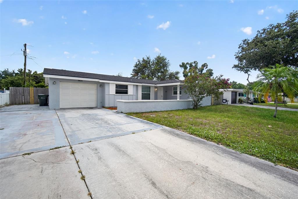 A single-story house with a gray exterior, a garage, and a concrete driveway — 3834 WARREN RIDGE STREET, SARASOTA, FL