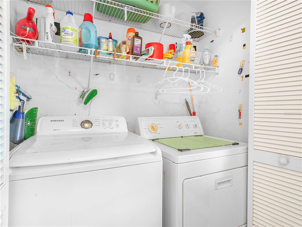 A screened-in porch features wicker furniture and a view of a pond — 17 RED QUILL CIRCLE, LAKE WALES, FL