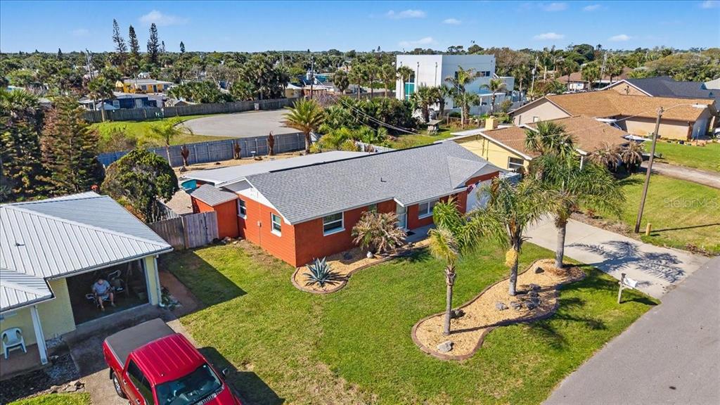 An aerial view shows a single-story orange house with a gray roof and palm trees — 18 CONCORD DRIVE, ORMOND BEACH, FL