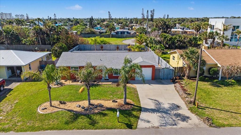An aerial view of a single-story house with a gray roof, palm trees, and driveway — 18 CONCORD DRIVE, ORMOND BEACH, FL
