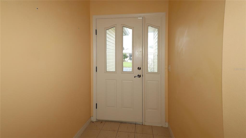 An interior entryway features a white front door with glass panels and tiled flooring — 17700 SE 92ND GRANTHAM TERRACE, THE VILLAGES, FL
