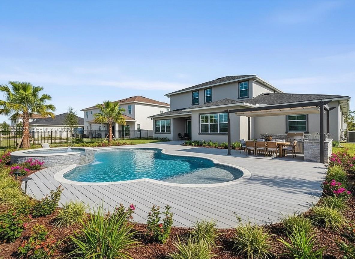 A backyard features a swimming pool with a spa, a patio, and a pergola — 769 Hookline Cir, Loxahatchee FL 33470, LOXAHATCHEE, FL