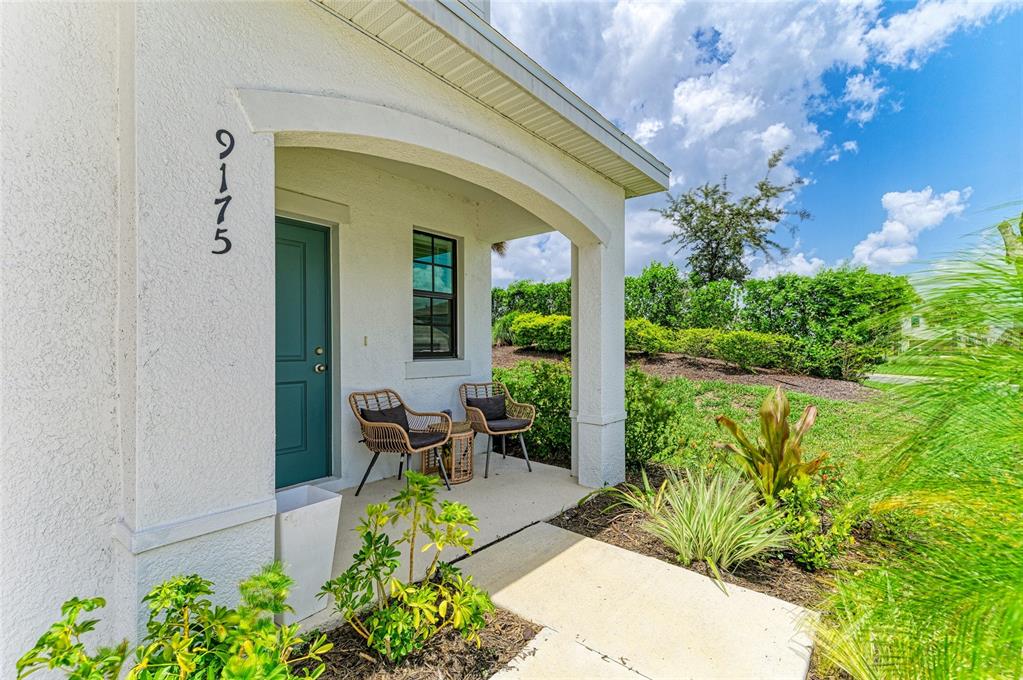 A two-story suburban house with a garage, light siding, and a small front yard — 9175 TEQUILA SUNRISE DRIVE, SARASOTA, FL