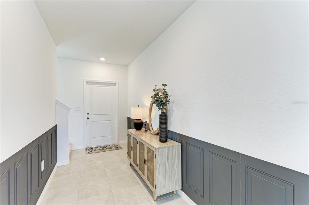 A covered front porch features a teal door, two wicker chairs, and a small table — 9175 TEQUILA SUNRISE DRIVE, SARASOTA, FL