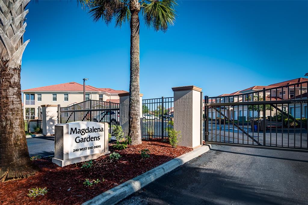 A gated entrance with a sign for Magdalena Gardens and multi-story residential buildings behind it — 240 W END DRIVE UNIT 713, PUNTA GORDA, FL