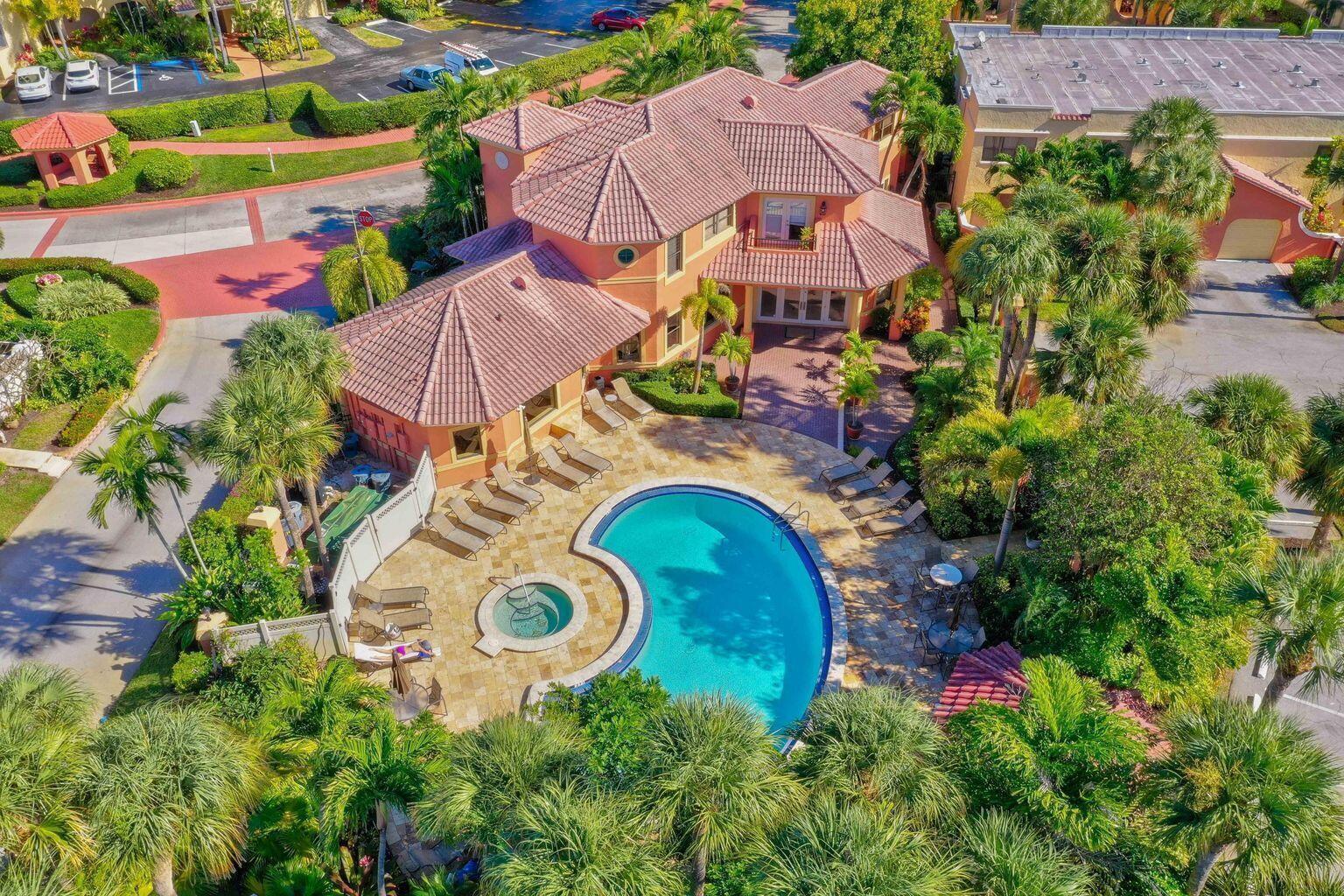 An aerial view of a two-story house with a pool, spa, and patio area — 400 Uno Lago Drive # 103, Juno Beach FL 33408, JUNO BEACH, FL