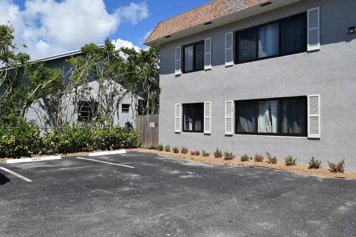 A two-story gray building with white shutters sits next to a paved guest parking area — 523 SE 20th Court # 5, Boynton Beach FL 33435, BOYNTON BEACH, FL