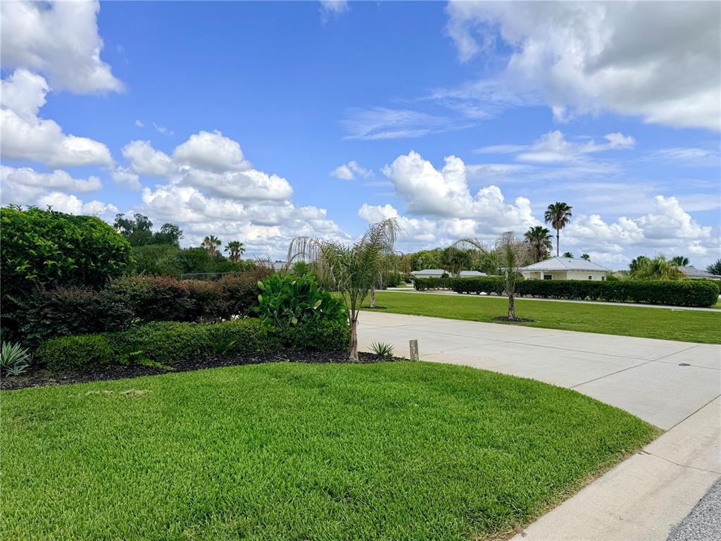 A paved driveway leads toward a house surrounded by a lawn and landscaped hedges — 4751 SE 94TH AVENUE, WEBSTER, FL