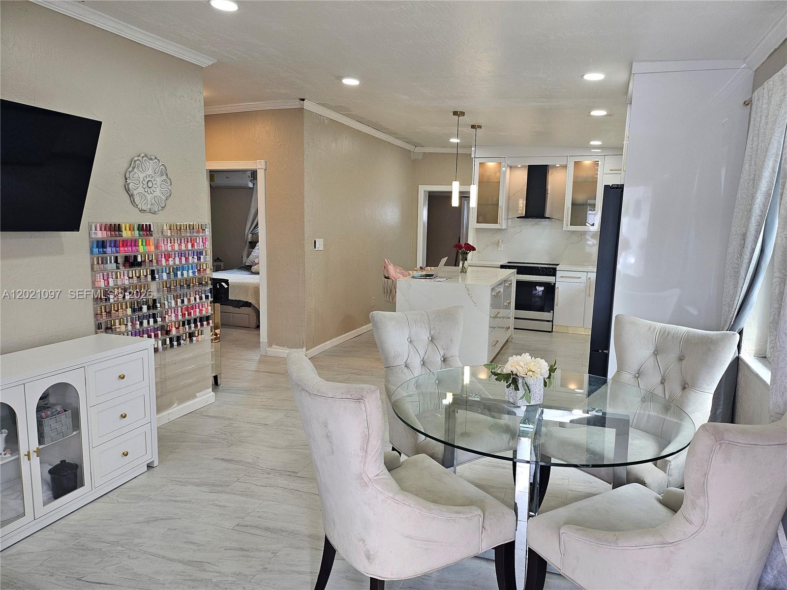 A dining area with a glass table and chairs sits before an open-concept kitchen — 528 NW 10th St, Florida City FL 33034, FLORIDA CITY, FL