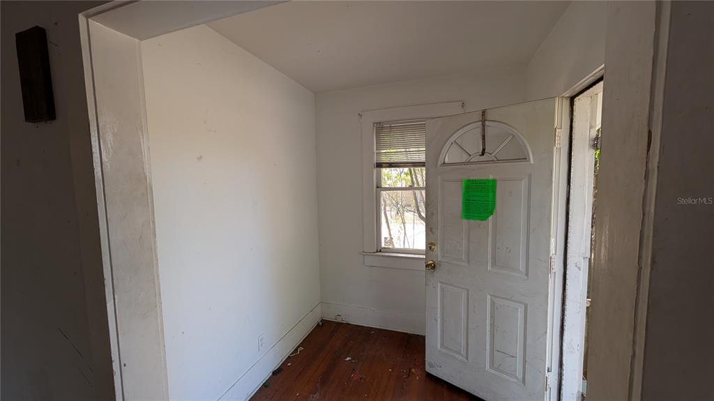 An interior view of a small room with hardwood floors, white walls, and an open door — 114 S BUNGALOW PARK AVENUE, TAMPA, FL