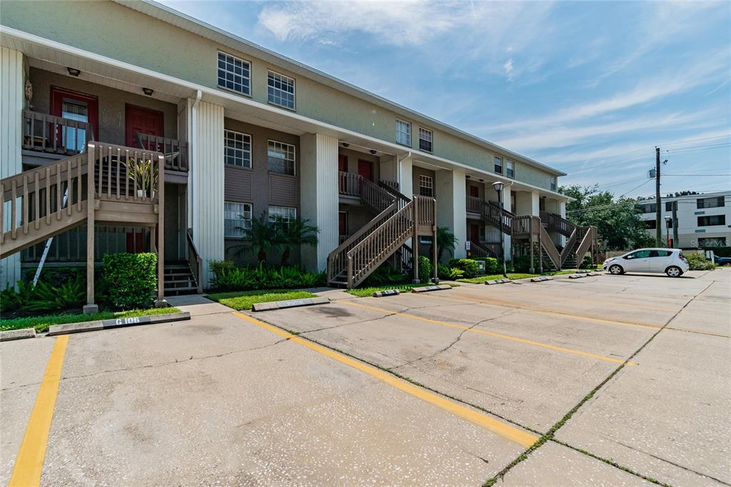 A multi-story apartment building with exterior staircases and a paved parking lot in front — 4875 W MCELROY AVENUE UNIT G208, TAMPA, FL