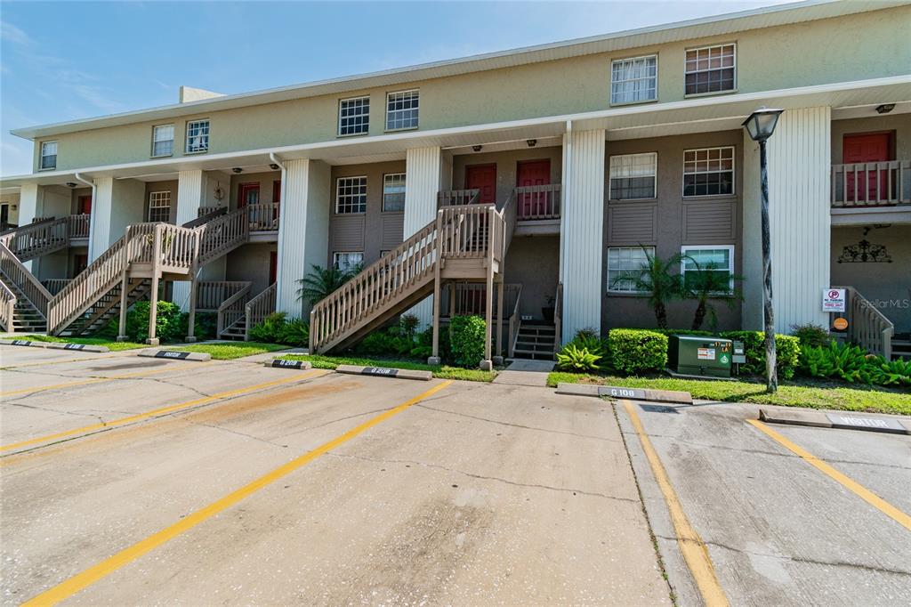 A multi-story apartment building with exterior staircases and assigned parking spaces in front — 4875 W MCELROY AVENUE UNIT G208, TAMPA, FL