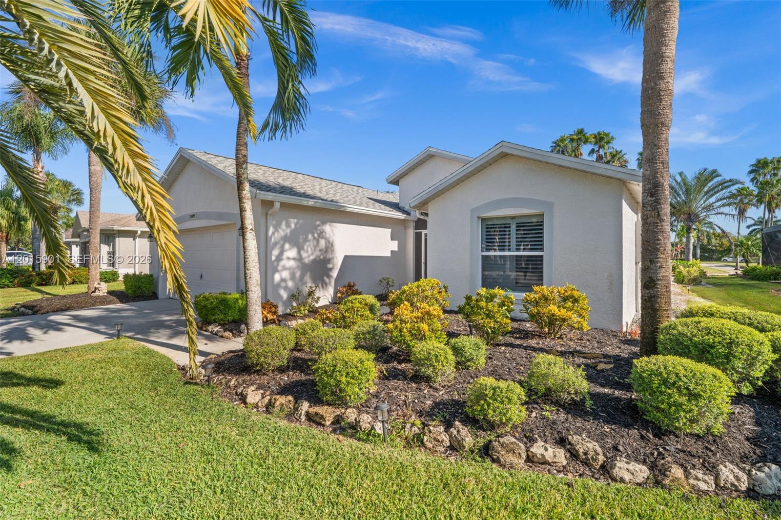 A single-story house with a garage, light-colored stucco walls, and landscaped front yard — 21489 SHERIDAN RUN, Estero FL 33928, ESTERO, FL