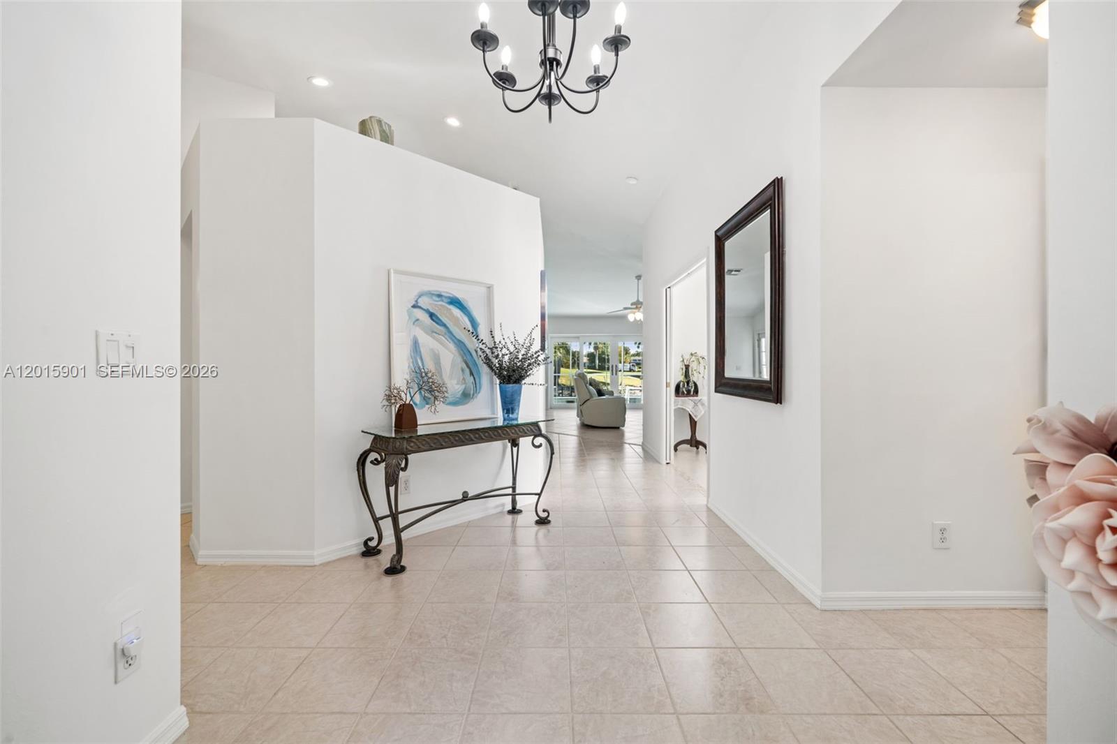 A bright entryway features tile flooring, a chandelier, a console table, and a framed painting — 21489 SHERIDAN RUN, Estero FL 33928, ESTERO, FL
