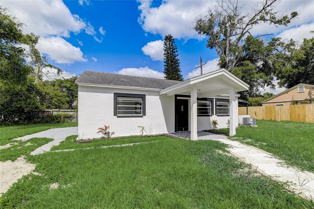 A small, white, single-story house with a covered front porch and a grassy yard — 2600 S CRYSTAL LAKE DRIVE, ORLANDO, FL
