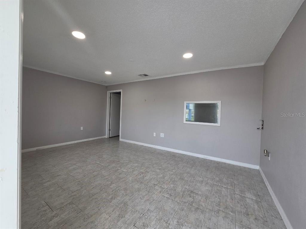 An empty room features gray walls, recessed lighting, and light-colored tile flooring — 7154 CONGRESS STREET, NEW PORT RICHEY, FL