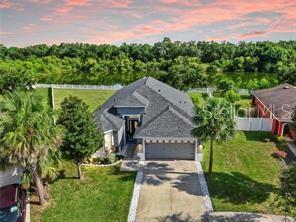 An aerial view of a single-story house with a gray roof and a concrete driveway — 7514 FOREST MERE DRIVE, RIVERVIEW, FL