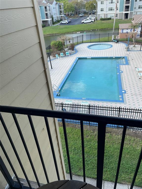 An elevated view from a balcony overlooks a swimming pool, hot tub, and apartment buildings — 2210 GRAND CAYMAN COURT UNIT 1737, KISSIMMEE, FL