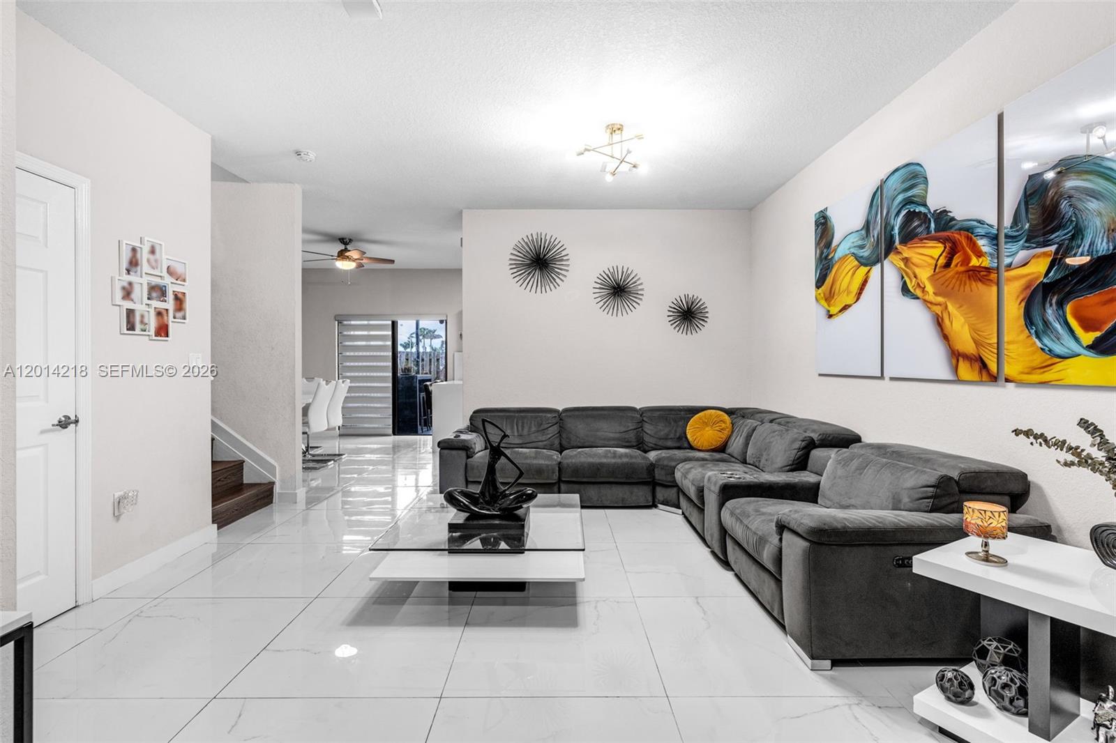 A living room features a large grey sectional sofa, a glass coffee table, and white tile flooring — 23082 SW 127th Pl # 0, Miami FL 33170, MIAMI, FL