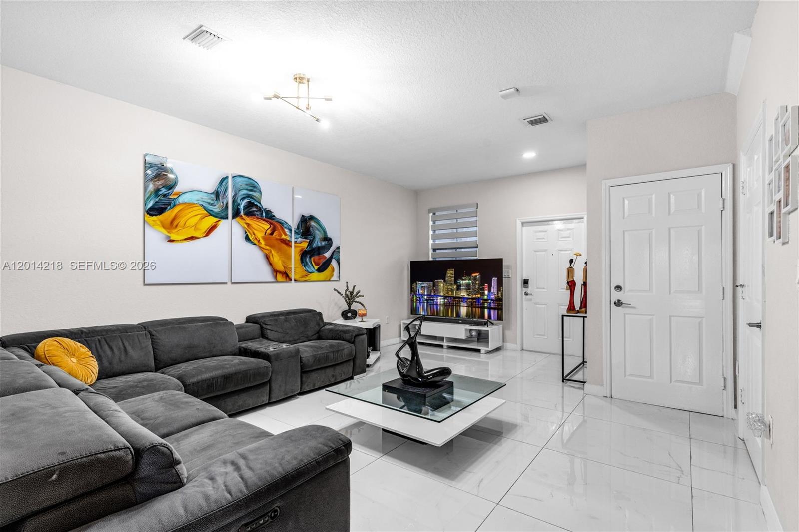 A living room features a large gray sectional, a glass coffee table, and white tile flooring — 23082 SW 127th Pl # 0, Miami FL 33170, MIAMI, FL