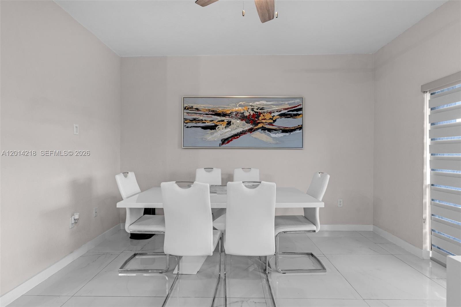A dining room features a white table, six modern chairs, and abstract wall art — 23082 SW 127th Pl # 0, Miami FL 33170, MIAMI, FL