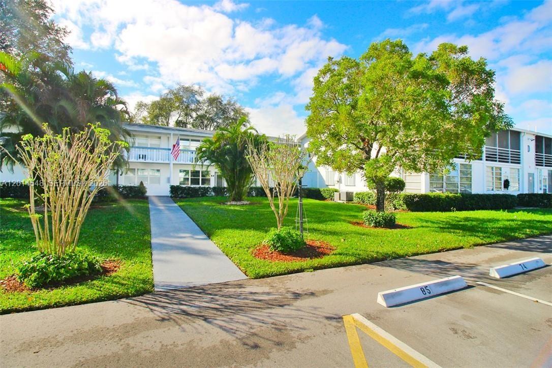 A two-story apartment building with a lawn, walkway, and parking spaces in the foreground — 70 Prescott D # 70, Deerfield Beach FL 33442, DEERFIELD BEACH, FL