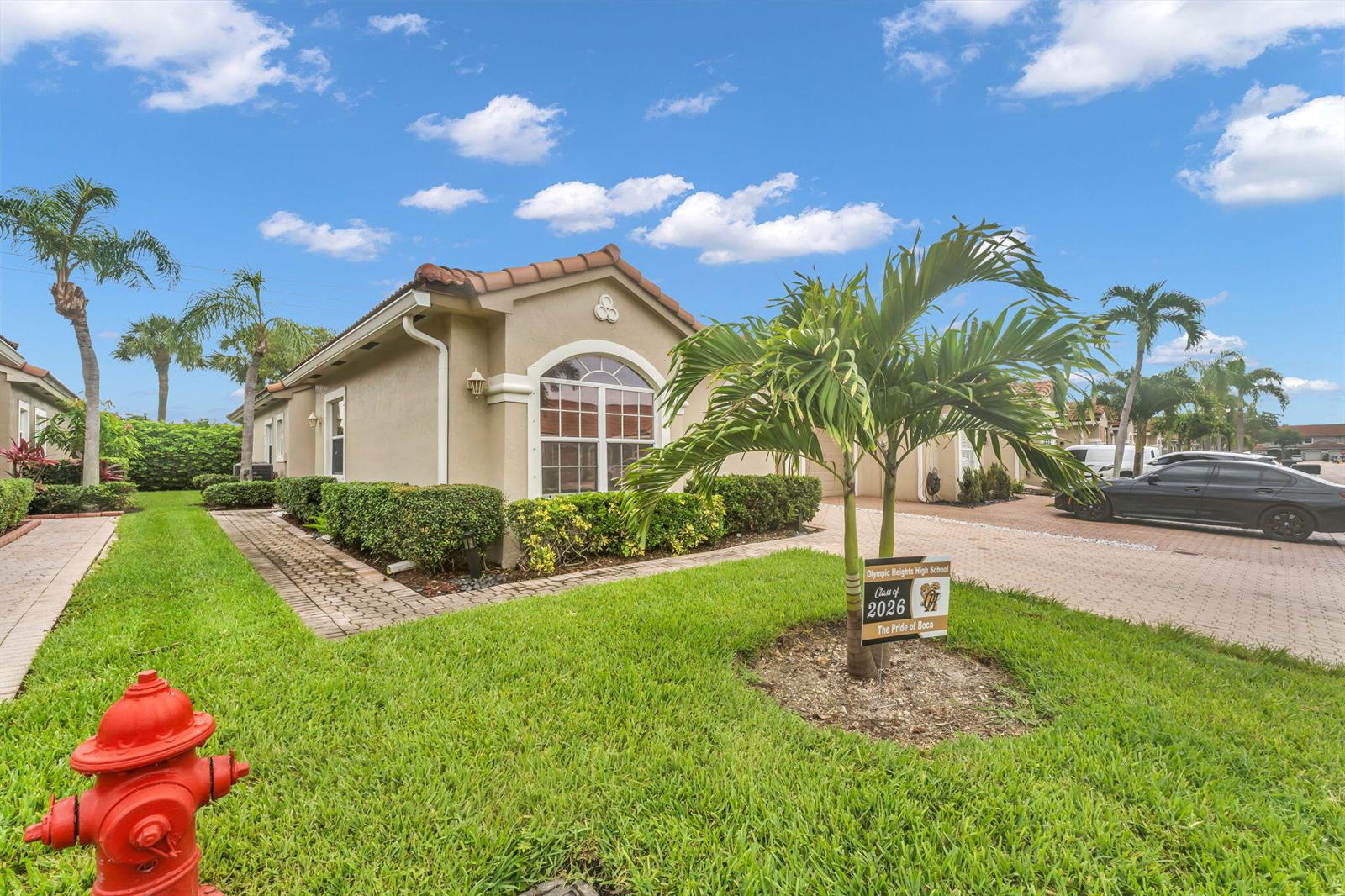 A tan stucco house with a tiled roof sits behind a lawn with a fire hydrant — 8385 Vía Serena, Boca Raton FL 33433, BOCA RATON, FL