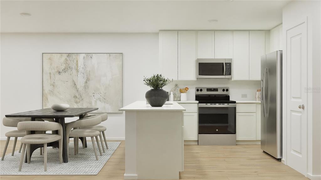 A modern kitchen features white cabinetry, stainless steel appliances, a center island, and dining area — 5609 MORANT BAY PATH, KISSIMMEE, FL