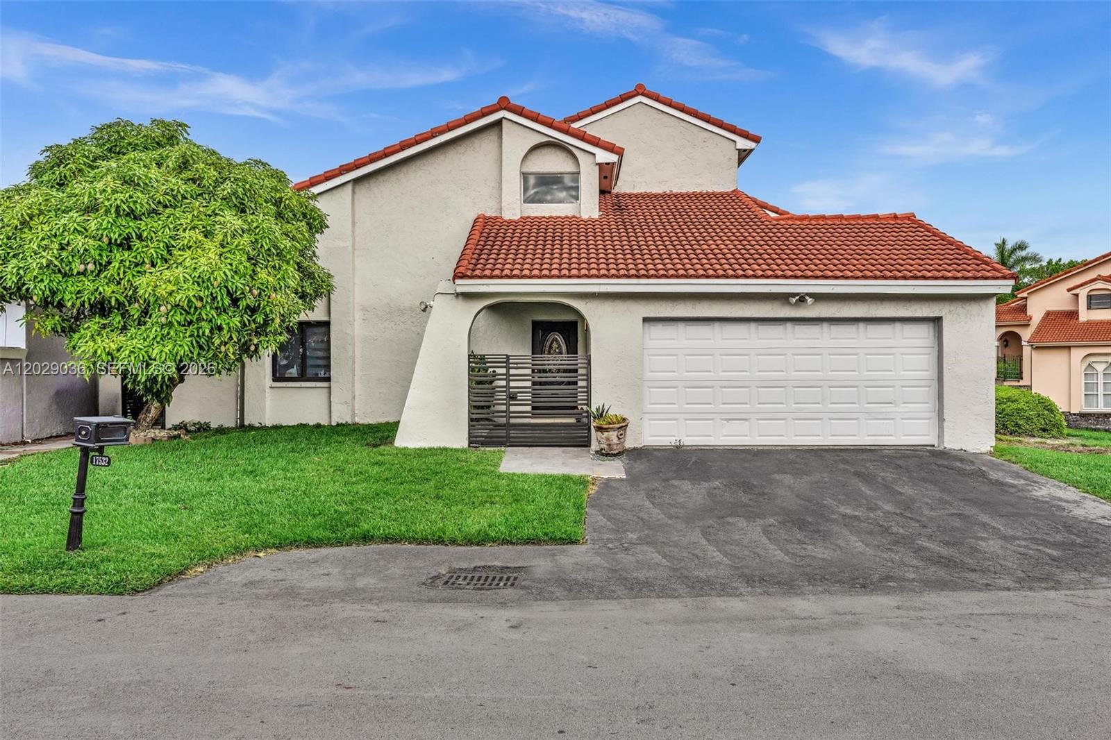 A two-story house with a white stucco exterior, red tile roof, and a two-car garage — 17532 NW 61st CT N, Hialeah FL 33015, HIALEAH, FL