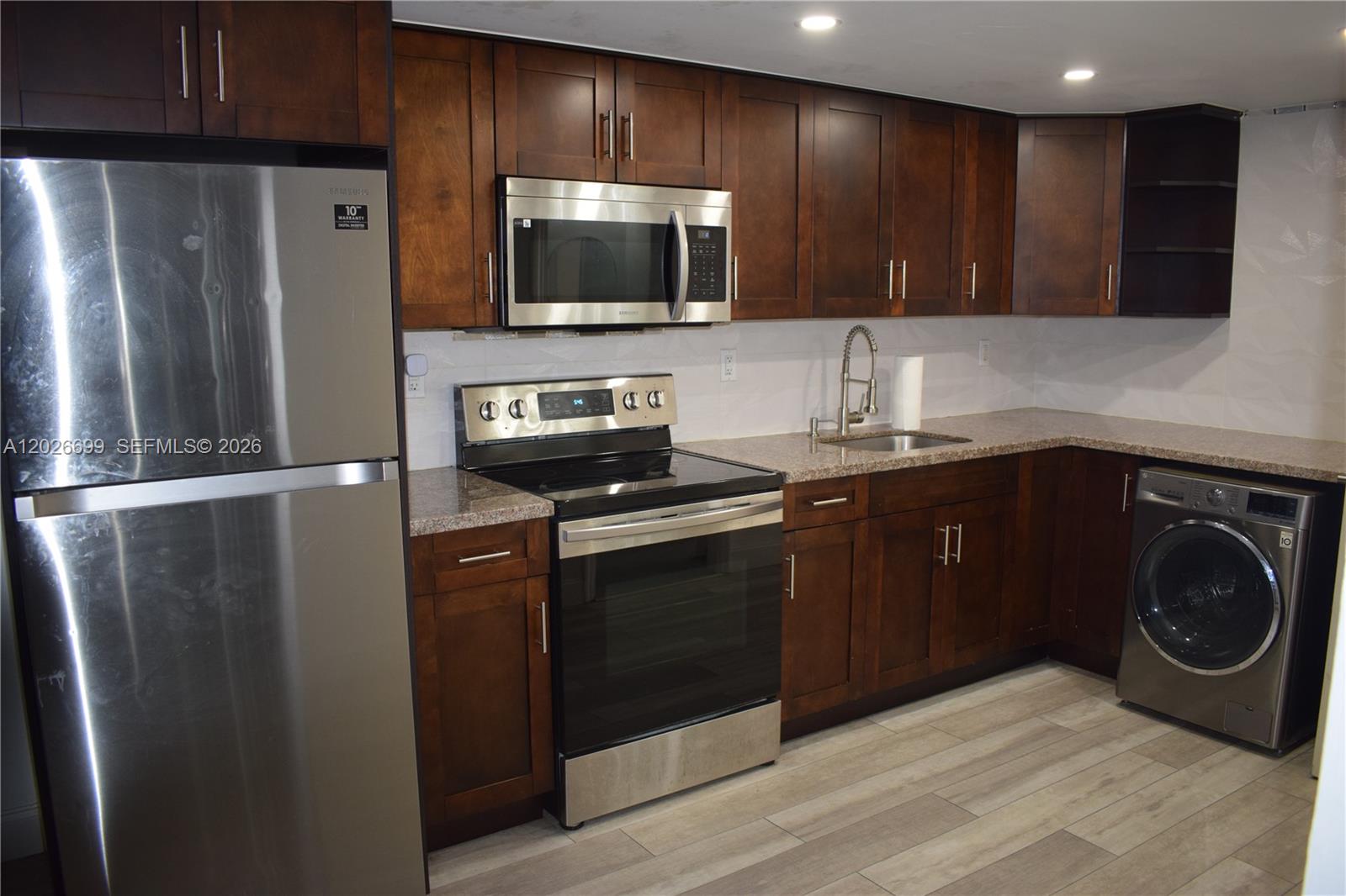 A kitchen features dark wood cabinets, stainless steel appliances, a sink, and a built-in washer — 777 SW 9th Ave # 420, Miami FL 33130, MIAMI, FL