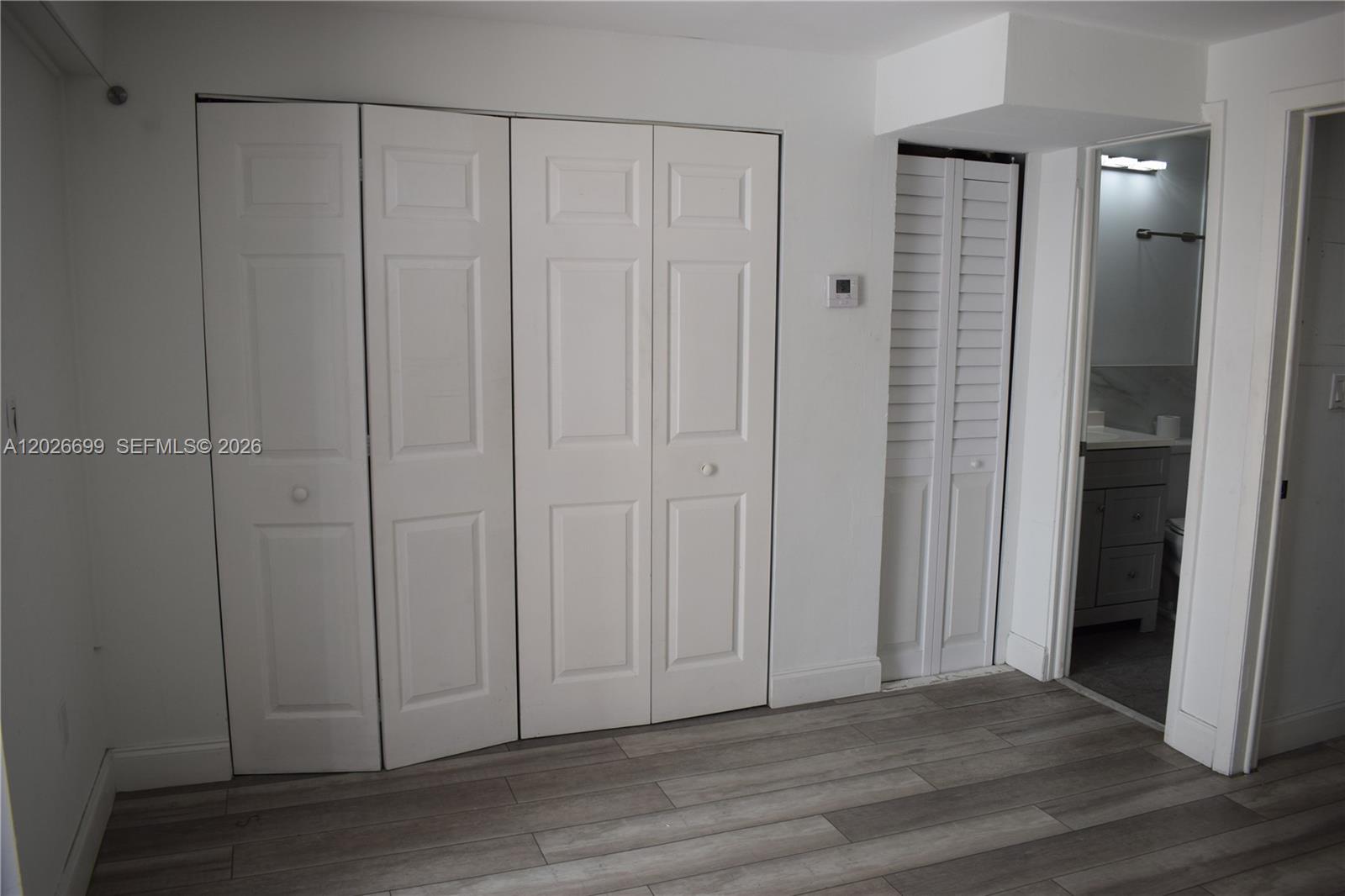 A room features white paneled closet doors, a louvered door, and wood-look flooring — 777 SW 9th Ave # 420, Miami FL 33130, MIAMI, FL
