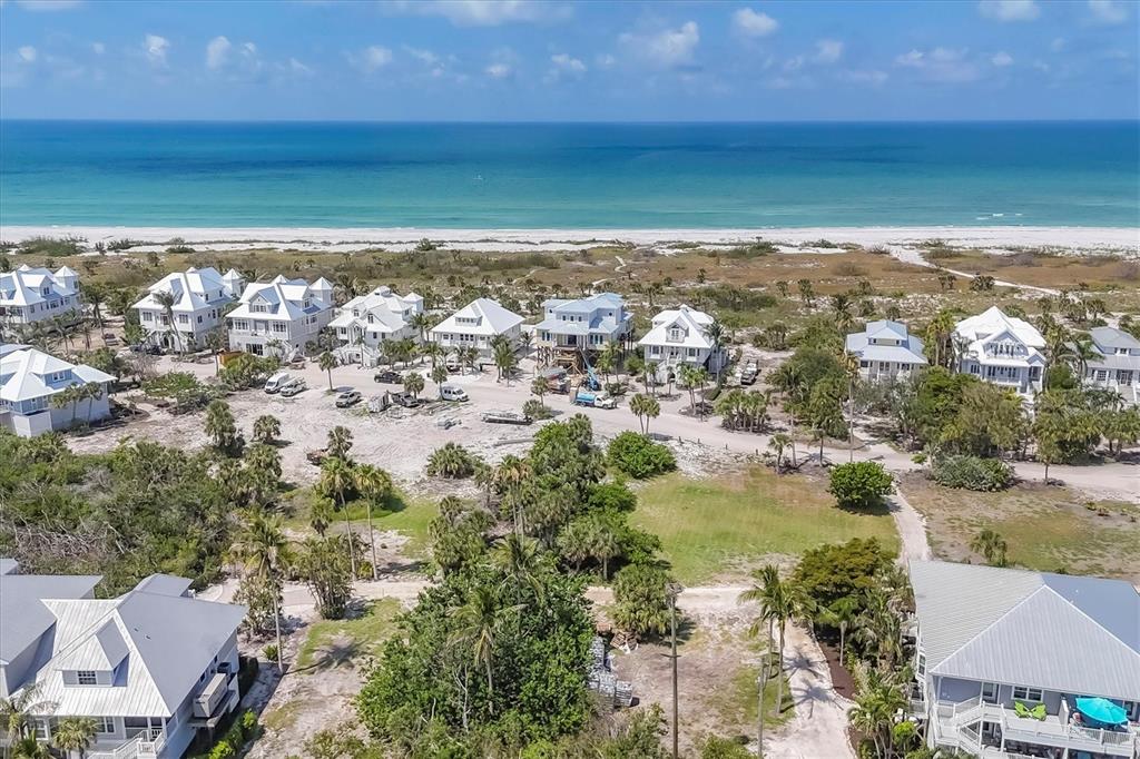An aerial view shows several coastal houses situated near a sandy beach and the ocean — 7365 PALM ISLAND DRIVE, PLACIDA, FL