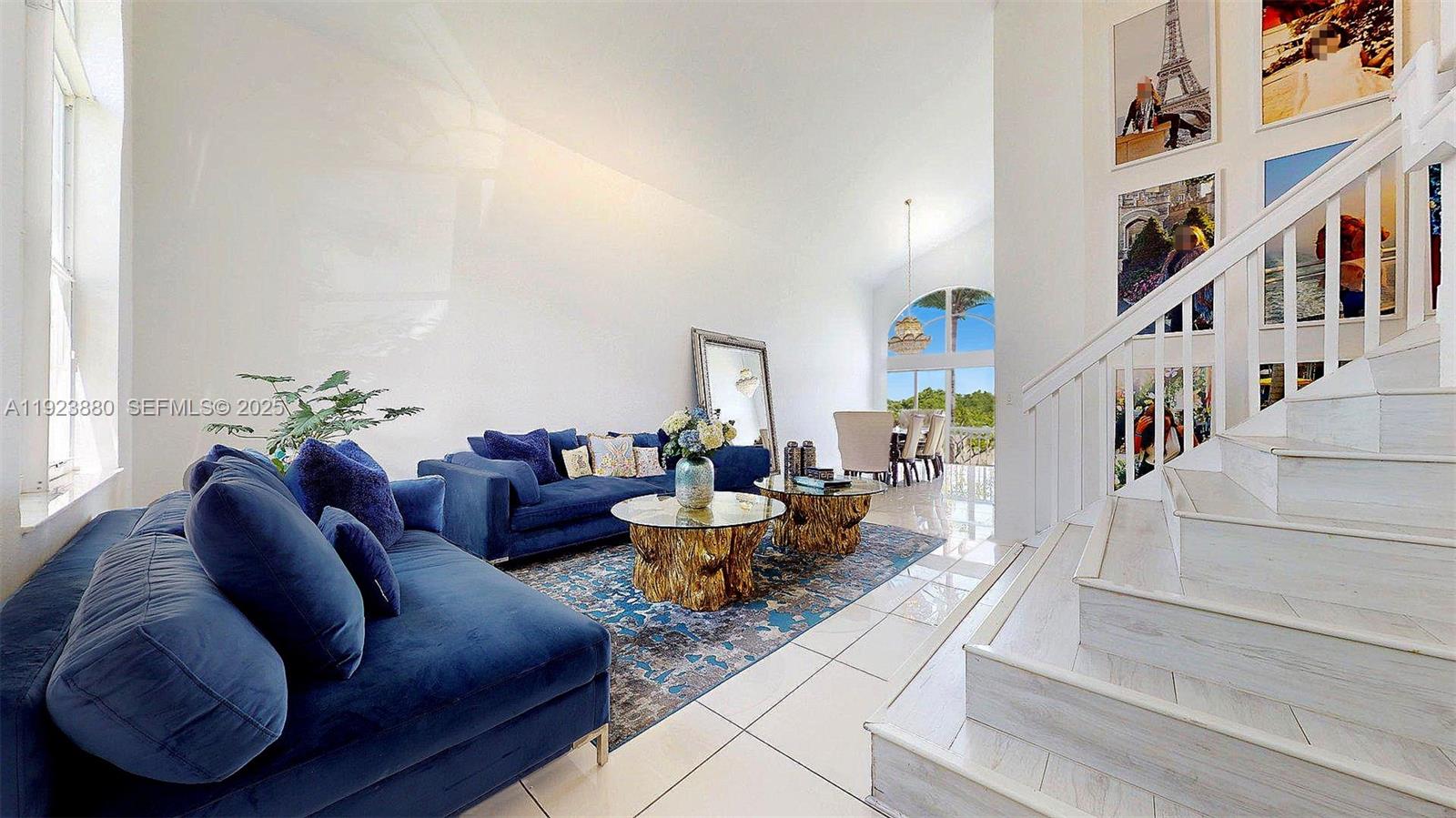 A living room features blue velvet sofas, a gold-based coffee table, and a white staircase — 14633 SW 132nd Ave, Miami FL 33186, MIAMI, FL