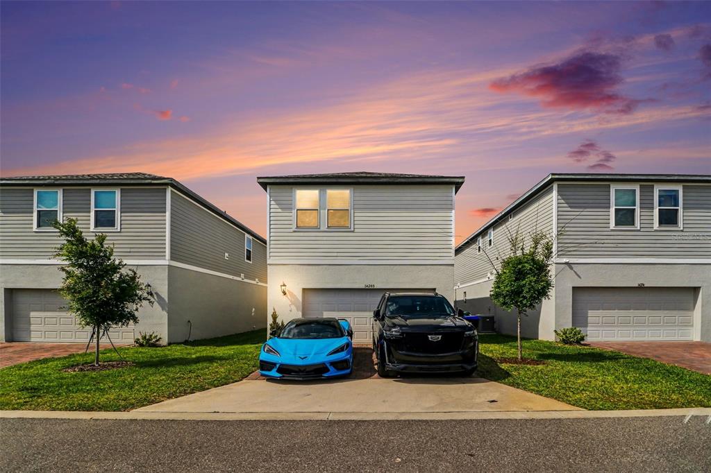 A blue sports car and a black SUV are parked in front of a suburban house — 14280 BRAEMAR STREET, WINTER GARDEN, FL